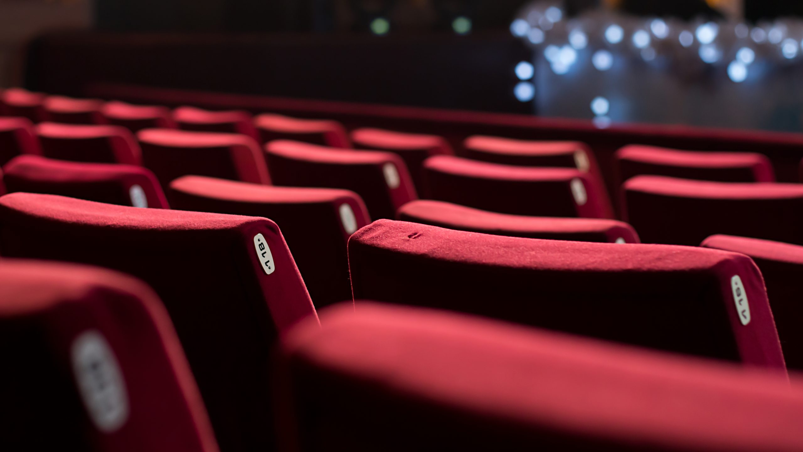 Empty cinema hall with red chairs.